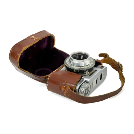 Appareil photo miniature Lumière Eljy sorti de son étui en cuir marron