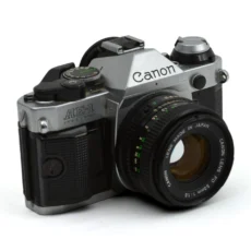 Appareil photo argentique Canon AE-1 Program vue de trois-quarts face avec objectif FD 50mm