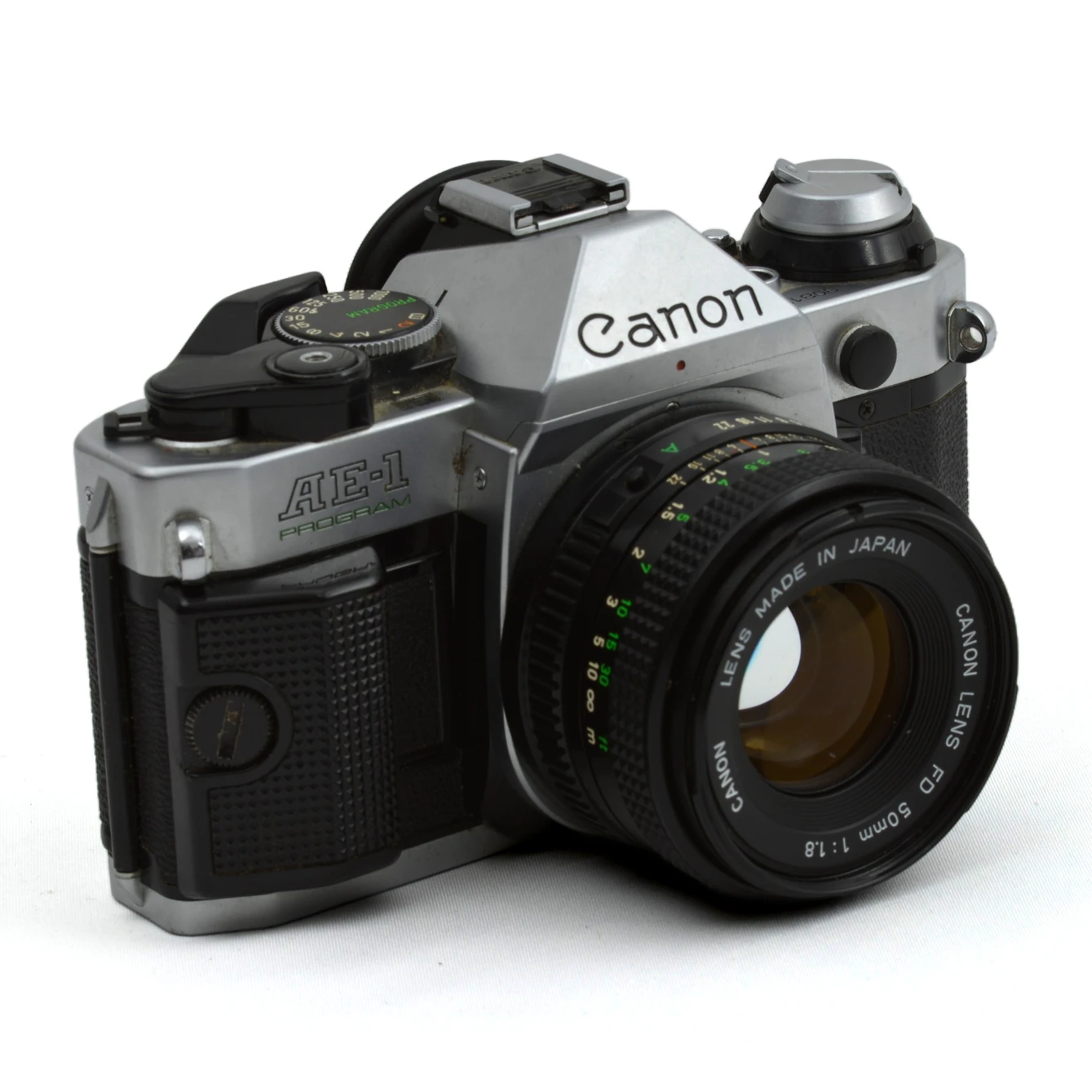 Appareil photo argentique Canon AE-1 Program vue de trois-quarts face avec objectif FD 50mm