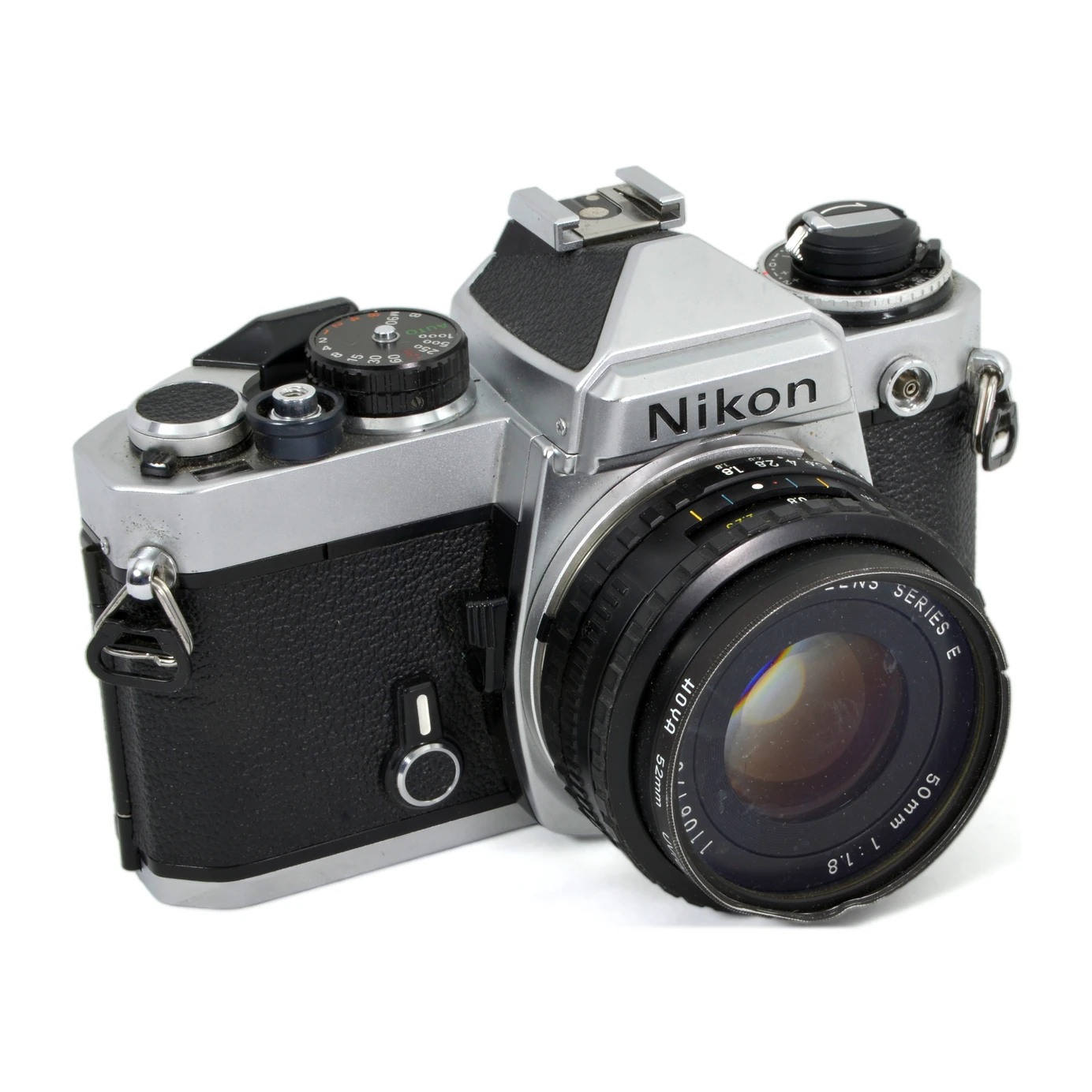 Appareil photo reflex argentique Nikon FE de face avec objectif 50mm f/1.8 et filtre cabossé