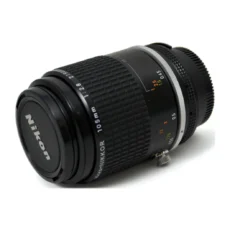 Objectif Nikon Micro-Nikkor 105mm f/2.8 AI-S vu de face avec son bouchon d'origine