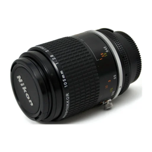 Objectif Nikon Micro-Nikkor 105mm f/2.8 AI-S vu de face avec son bouchon d'origine