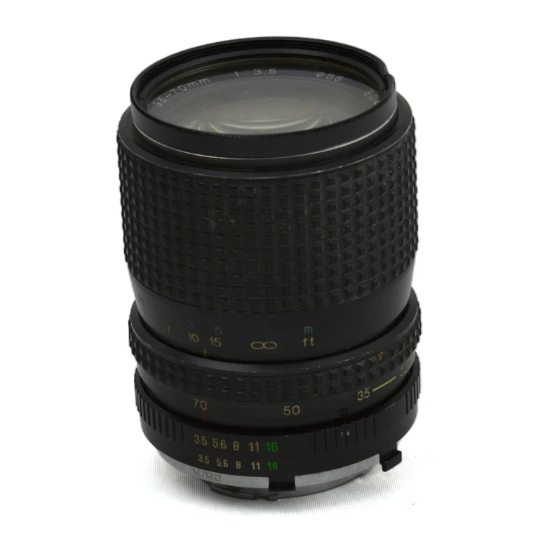 Objectif photo zoom manuel 35-70mm f/3.5 posé sur fond blanc