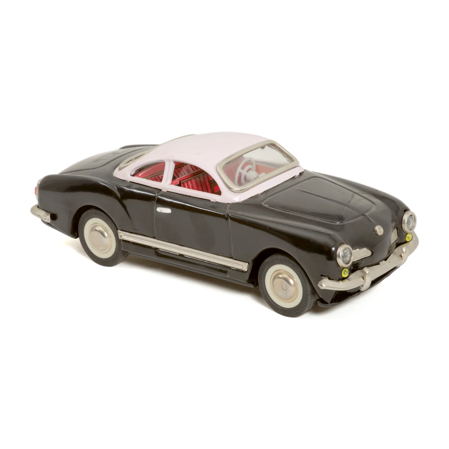 Voiture en tôle Volkswagen Karmann Ghia noire et rose vue de trois quarts avant