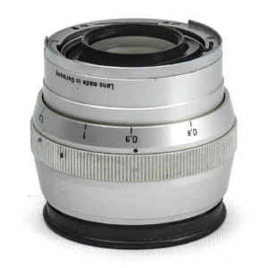 Vue de profil de l'objectif Carl Zeiss Sonnar 85mm f/2 argenté pour Contarex montrant la bague de mise au point