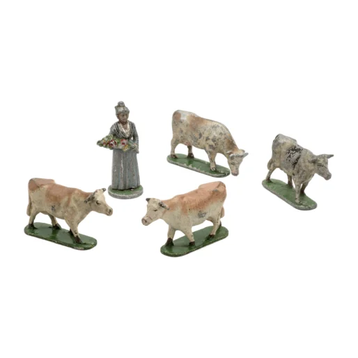 Lot de 5 figurines anciennes en plomb représentant une fermière et quatre vaches sur fond blanc