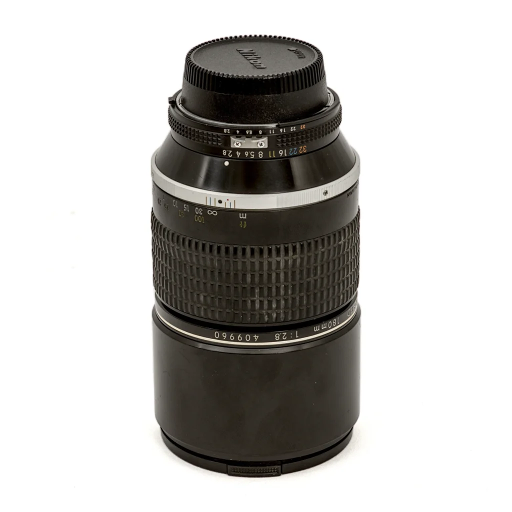 Objectif photo Nikon Nikkor 180mm f/2.8 ED AI-S vu de profil montrant la bague de diaphragme et le numéro de série