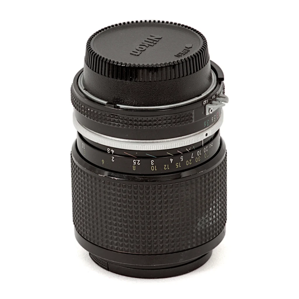Objectif Nikon Zoom-Nikkor 43-86mm f/3.5 AI vu de face avec son bouchon