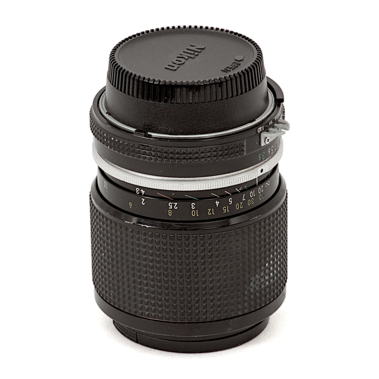 Objectif Nikon Zoom-Nikkor 43-86mm f/3.5 AI vu de face avec son bouchon