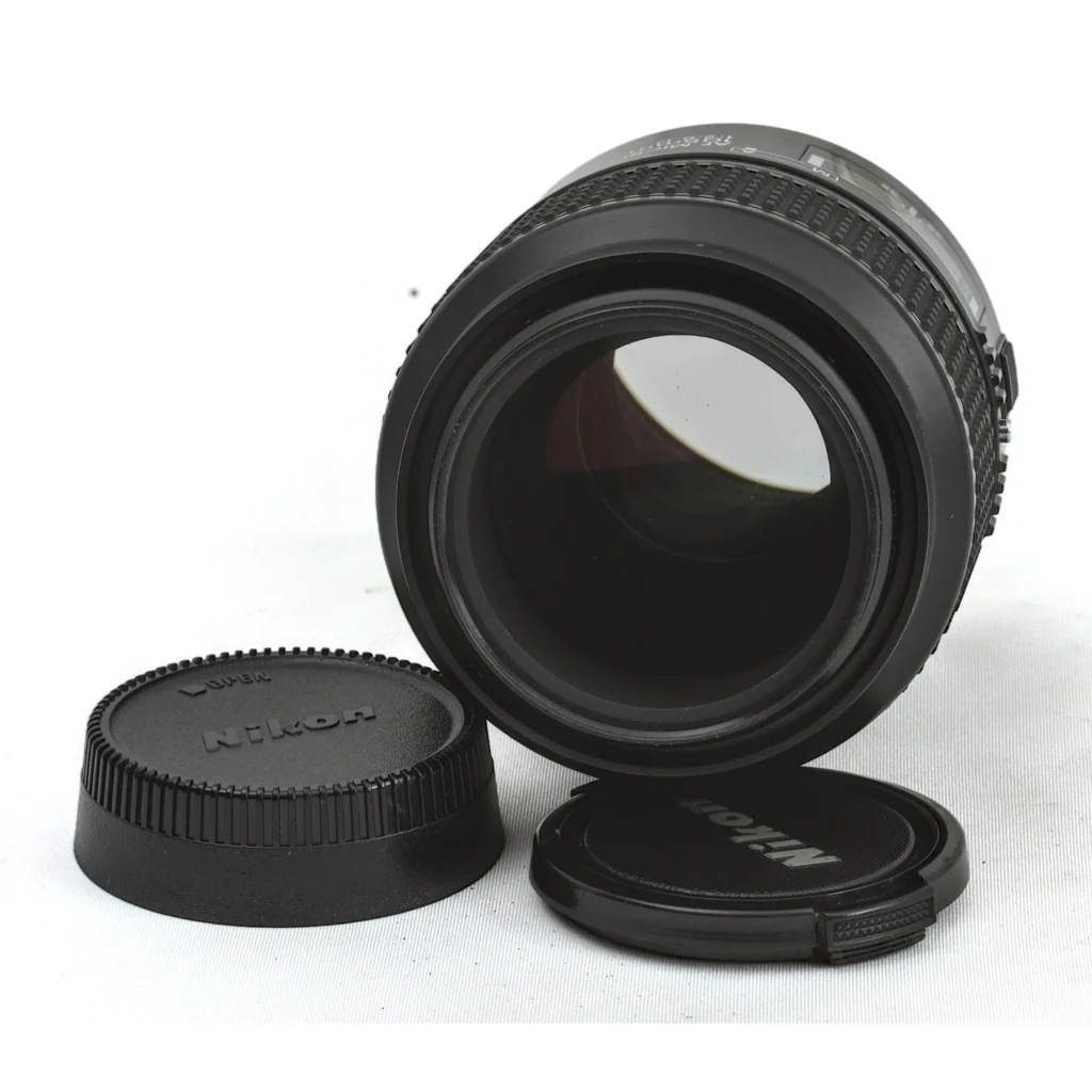Objectif Nikon 105mm f/2.8D accompagné de ses bouchons avant et arrière d'origine