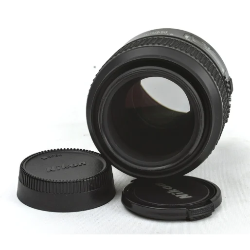 Objectif Nikon 105mm f/2.8D accompagné de ses bouchons avant et arrière d'origine