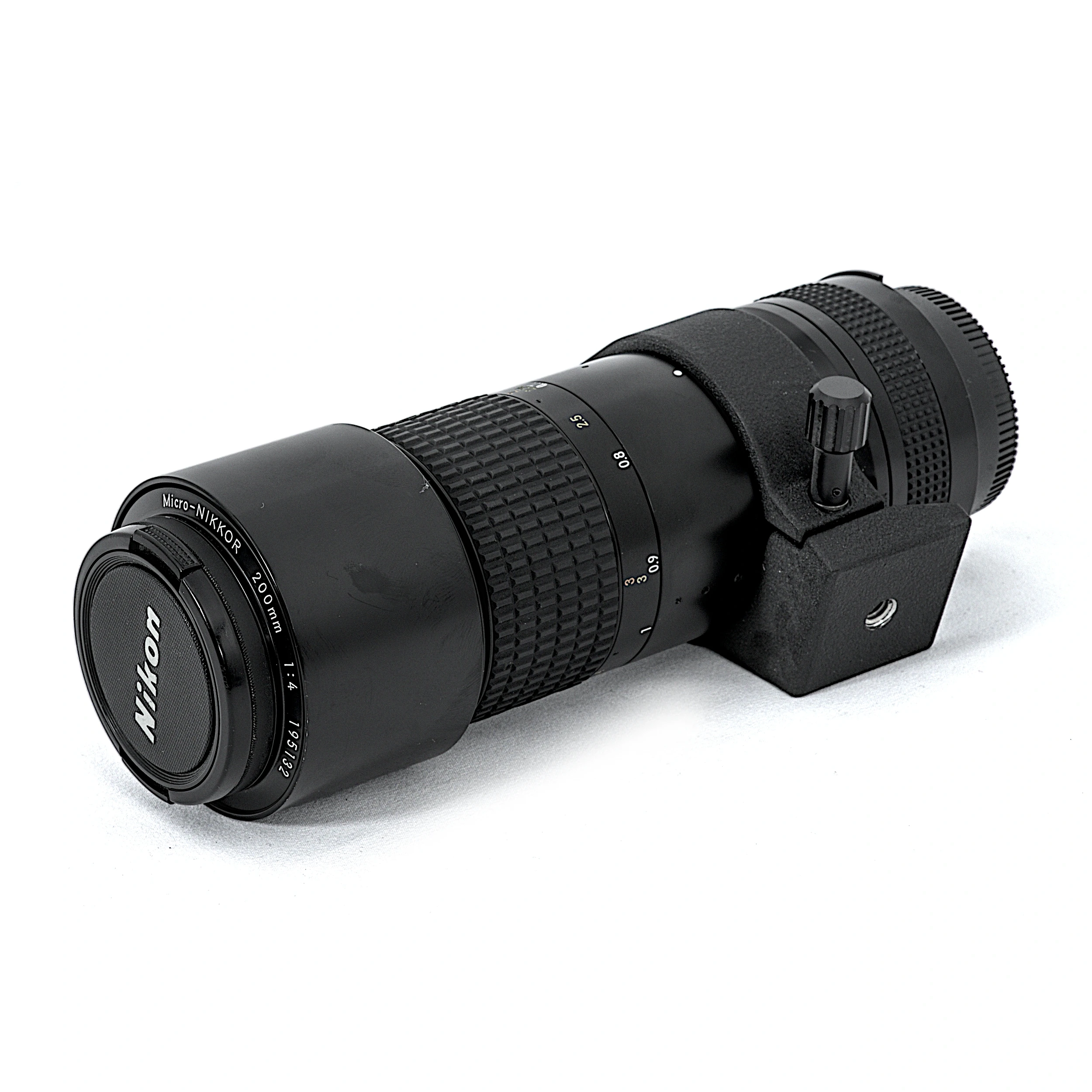 Objectif Nikon Micro-Nikkor 200mm f/4 IF AI-S posé à plat avec son collier de pied