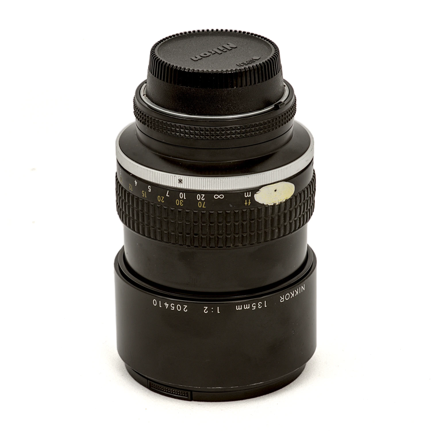 Objectif Nikon Nikkor 135mm f/2 AI-s vu de profil avec pare-soleil rétracté