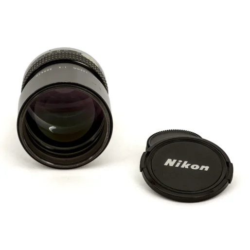 Lentille frontale de l'objectif Nikon 135mm f/2 et son bouchon