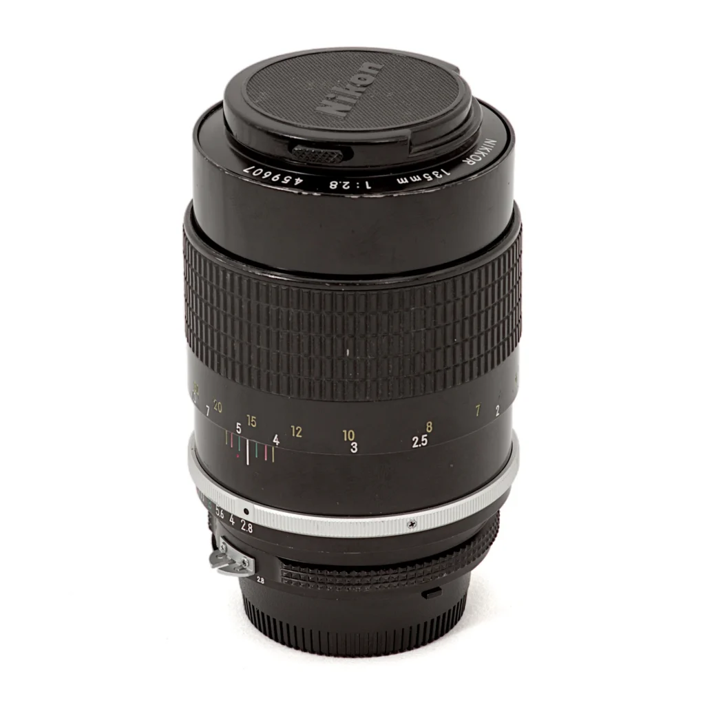Objectif Nikon Nikkor 135mm f/2.8 AI avec son bouchon avant