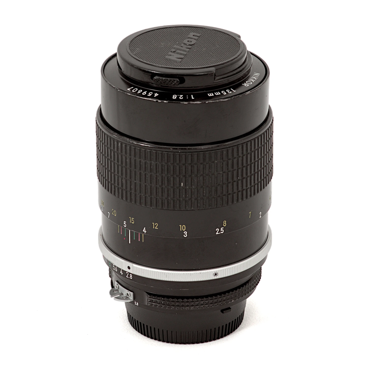 Objectif Nikon Nikkor 135mm f/2.8 AI avec son bouchon avant