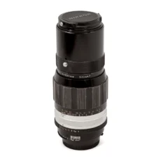 Objectif Nikon Nikkor 200mm f/4 Non-AI debout avec son bouchon avant