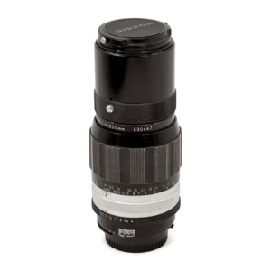 Objectif Nikon Nikkor 200mm f/4 Non-AI debout avec son bouchon avant