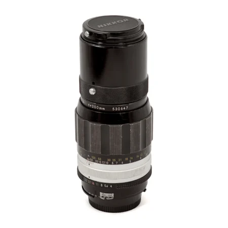 Objectif Nikon Nikkor 200mm f/4 Non-AI debout avec son bouchon avant