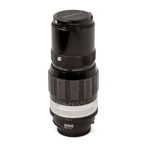 Objectif Nikon Nikkor 200mm f/4 Non-AI debout avec son bouchon avant