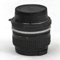 Objectif Nikon Nikkor 28mm f/3.5 de profil avec bouchon arrière