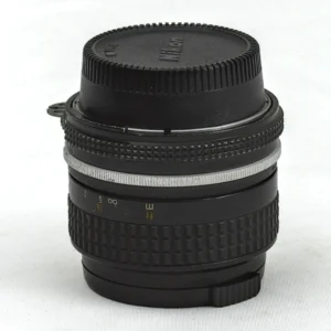 Objectif Nikon Nikkor 28mm f/3.5 de profil avec bouchon arrière