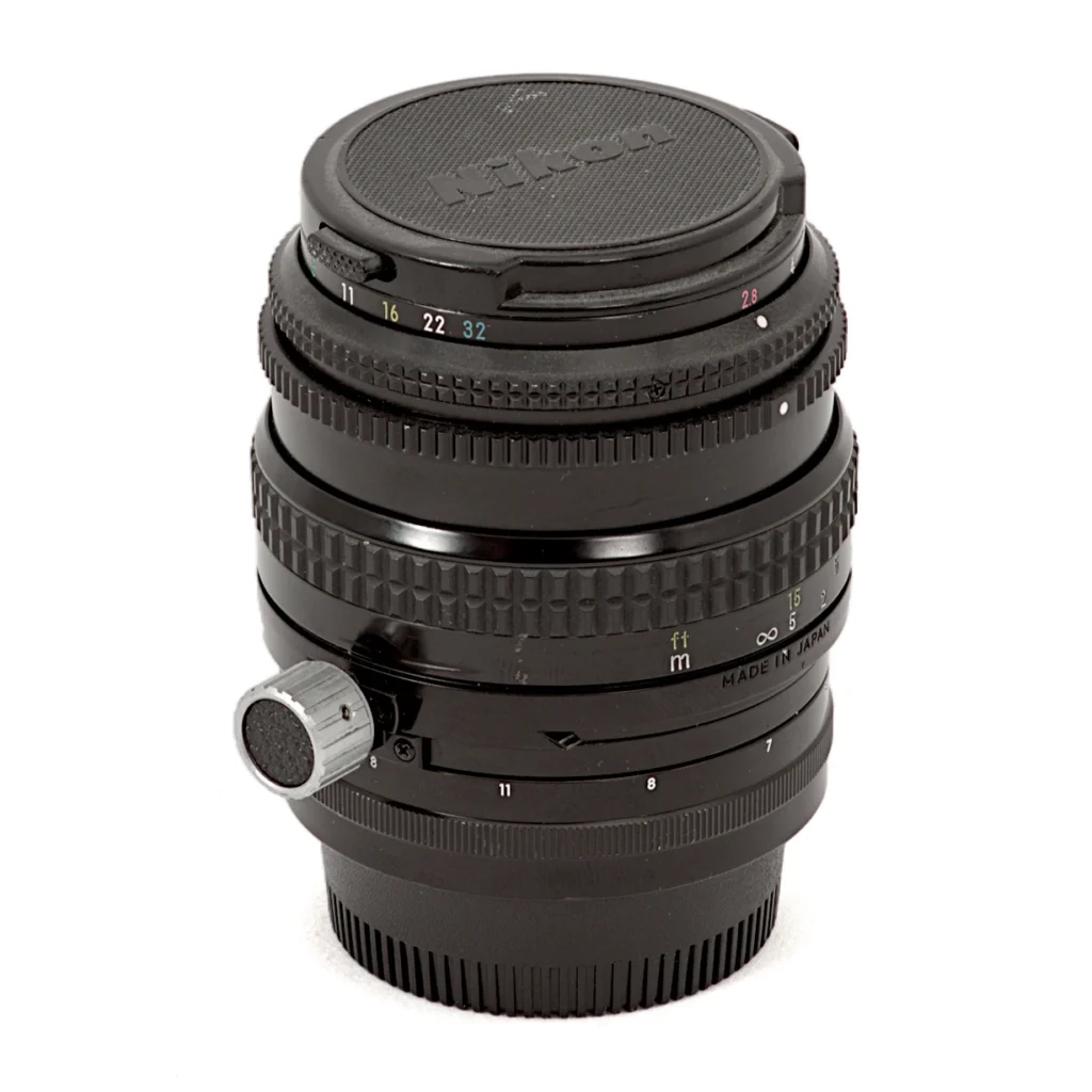 Objectif Nikon PC-Nikkor 35mm f/2.8 vu de face avec son bouchon d'origine