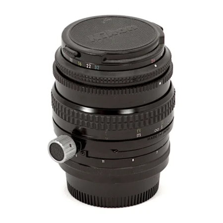 Objectif Nikon PC-Nikkor 35mm f/2.8 vu de face avec son bouchon d'origine