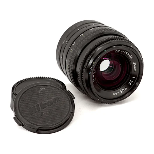 Objectif Nikon PC-Nikkor 35mm f/2.8 de profil montrant la lentille frontale et la molette de décentrement