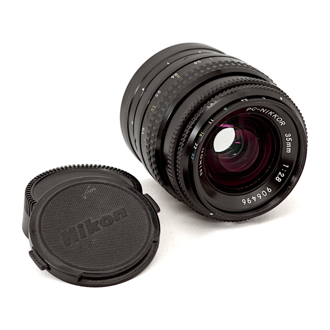 Objectif Nikon PC-Nikkor 35mm f/2.8 de profil montrant la lentille frontale et la molette de décentrement