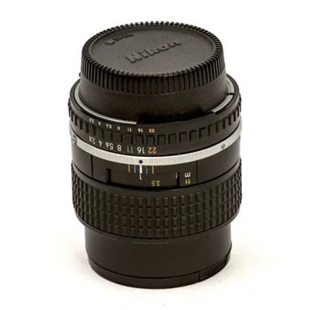 Objectif Nikon Lens Series E 100mm f/2.8 vu de face avec son bouchon
