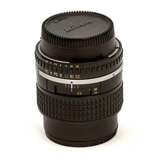 Objectif Nikon Lens Series E 100mm f/2.8 vu de face avec son bouchon