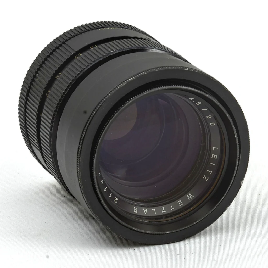 Vue de face de l'objectif Leica Elmarit 90mm f/2.8 montrant les inscriptions et le numéro de série
