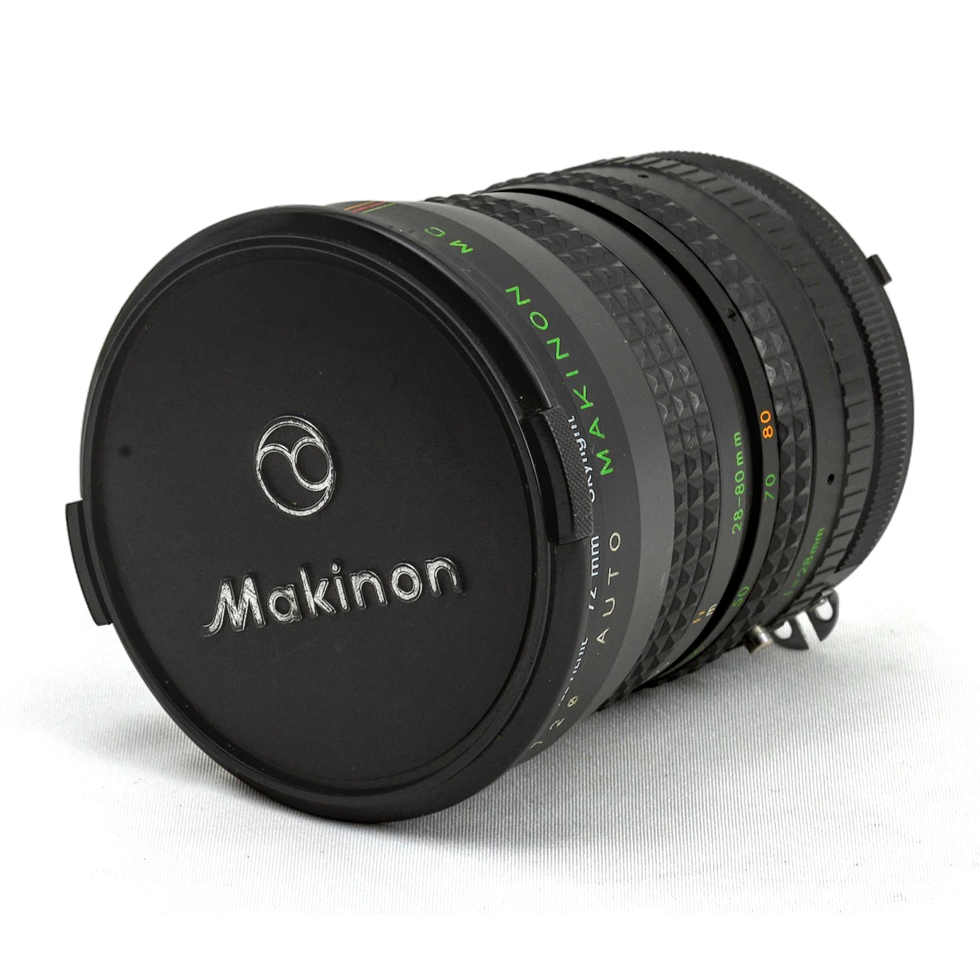 Objectif photo vintage Auto Makinon MC 28-80mm avec son bouchon avant d