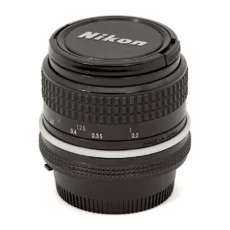 Objectif Nikon Nikkor 24mm f/2.8 AI posé avec ses bouchons