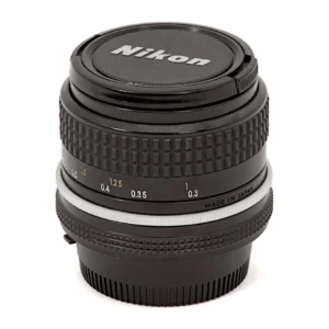 Objectif Nikon Nikkor 24mm f/2.8 AI posé avec ses bouchons