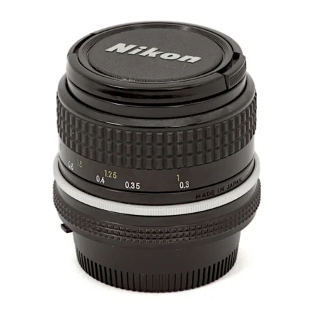 Objectif Nikon Nikkor 24mm f/2.8 AI posé avec ses bouchons