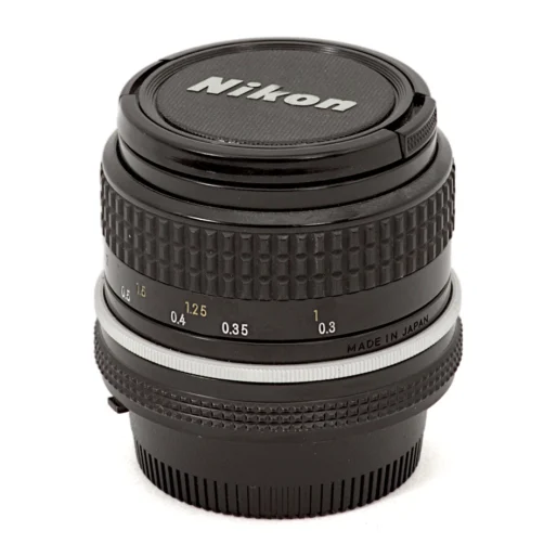 Objectif Nikon Nikkor 24mm f/2.8 AI posé avec ses bouchons