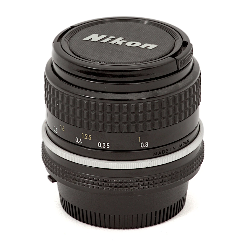 Objectif Nikon Nikkor 24mm f/2.8 AI posé avec ses bouchons