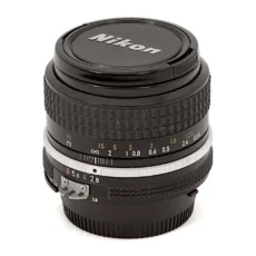 Objectif Nikon NIKKOR 35mm f/2.8 AI vu de face avec son bouchon d'origine
