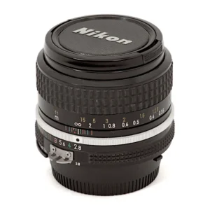 Objectif Nikon NIKKOR 35mm f/2.8 AI vu de face avec son bouchon d'origine