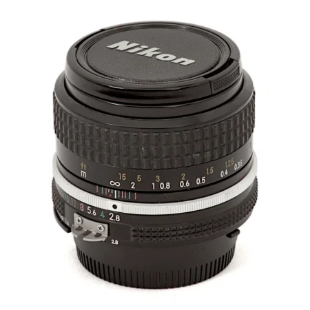 Objectif Nikon NIKKOR 35mm f/2.8 AI vu de face avec son bouchon d'origine