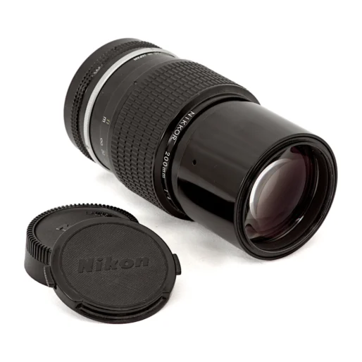 Objectif Nikon 200mm couché avec ses bouchons de protection d'origine