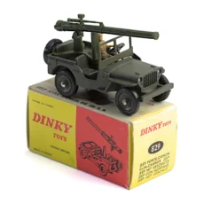 Jeep militaire Dinky Toys 829 porte-canon posée sur sa boîte d'origine jaune et rouge