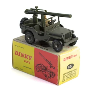 Jeep militaire Dinky Toys 829 porte-canon posée sur sa boîte d'origine jaune et rouge
