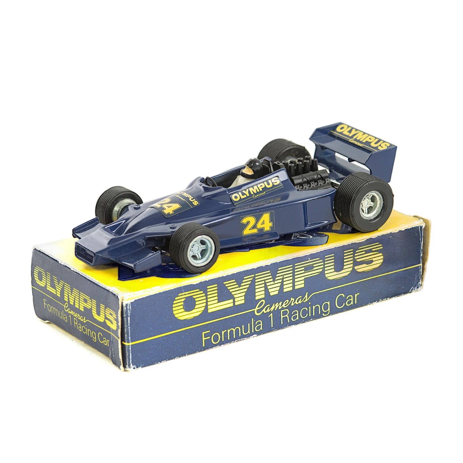 Voiture miniature Dinky Toys Hesketh 308E Olympus bleue posée sur sa boîte d
