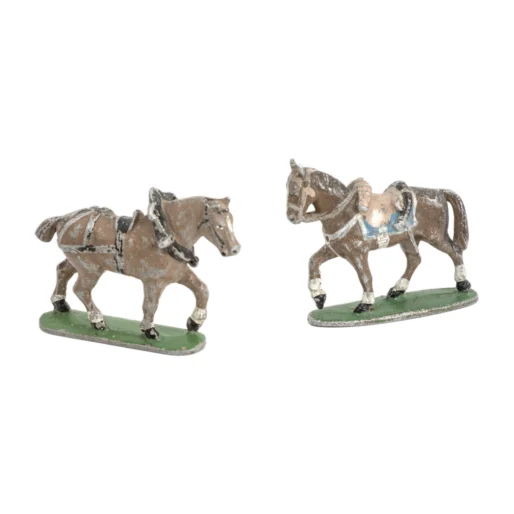Vue de profil de deux figurines anciennes de chevaux en plomb peint avec usure