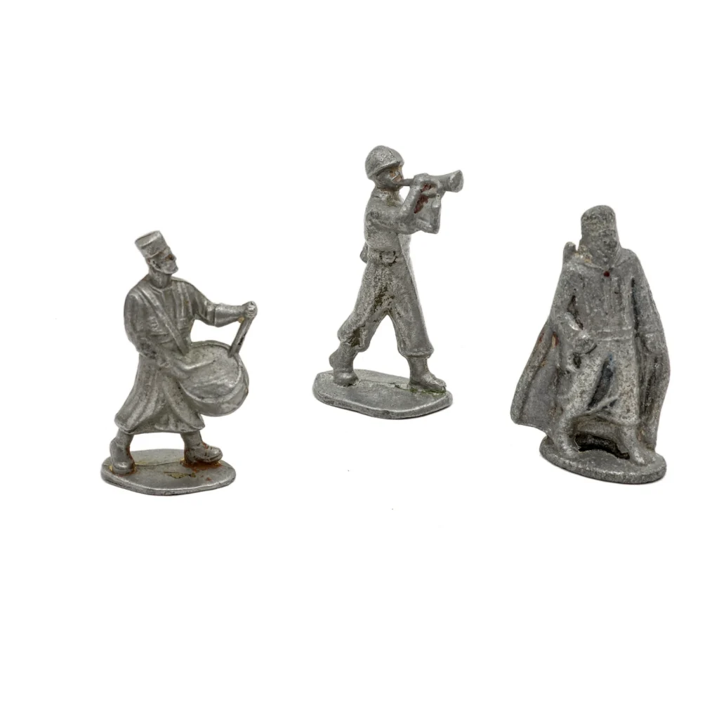 Vue de face de trois figurines anciennes en plomb : un tambour