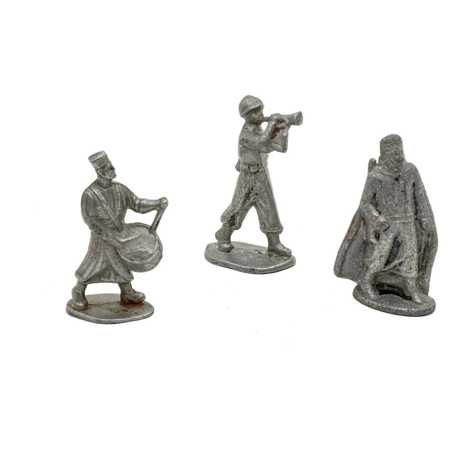 Vue de face de trois figurines anciennes en plomb : un tambour