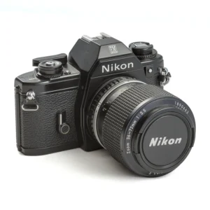 Appareil photo reflex argentique Nikon EM de trois-quarts avec objectif